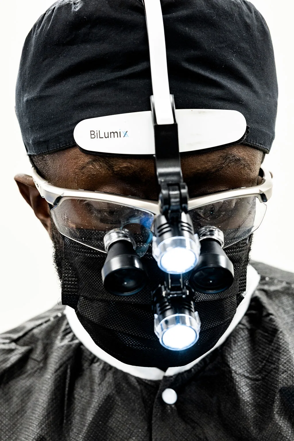 Dr. Ennuson wearing magnification loupes and a mask